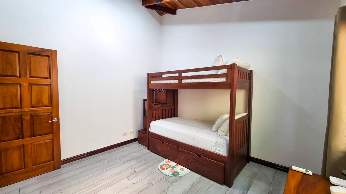 Bunk bedroom with hardwood bunk bed and vaulted ceiling - perfect for kids