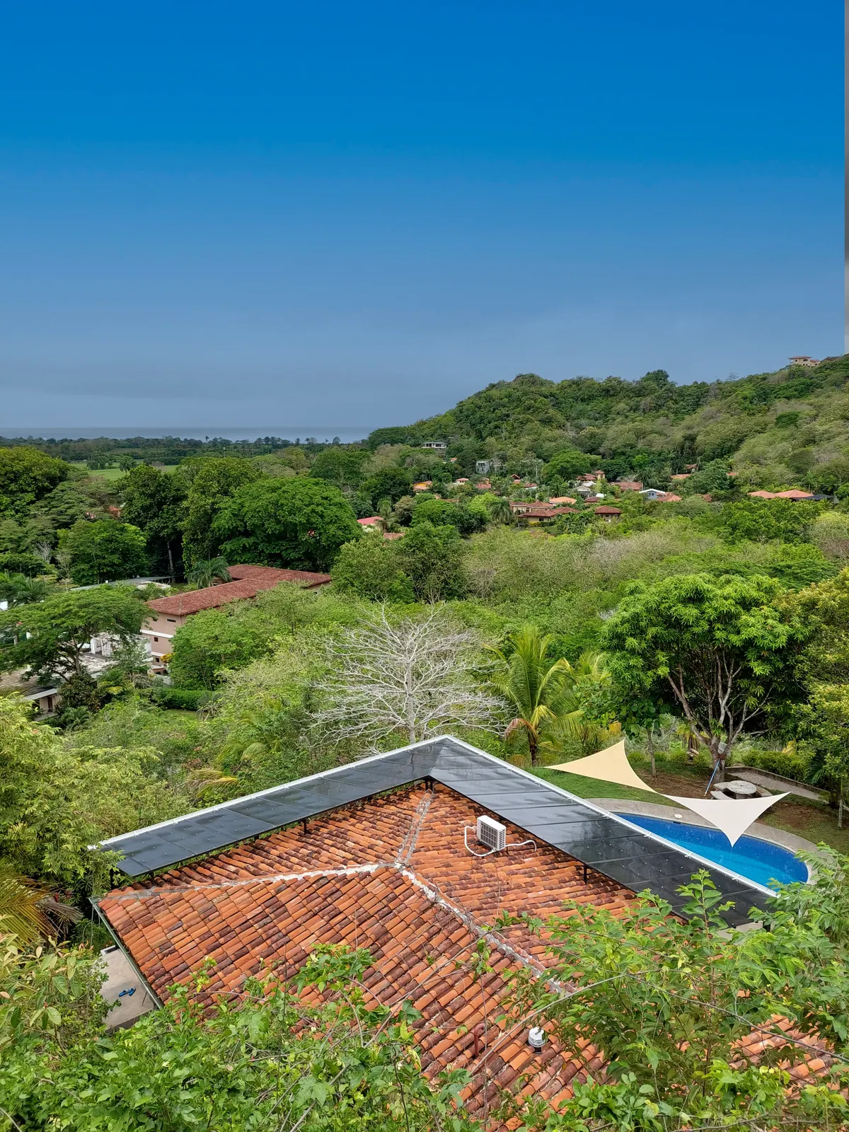 Aerial view over the villa rooftop toward the Pacific Ocean