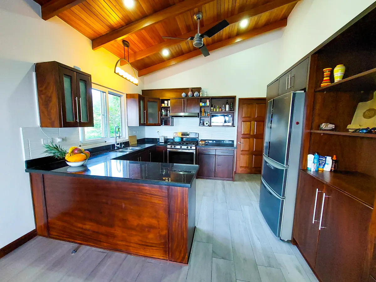 Kitchen with hardwood island, fresh fruit bowl, and vaulted wood ceiling