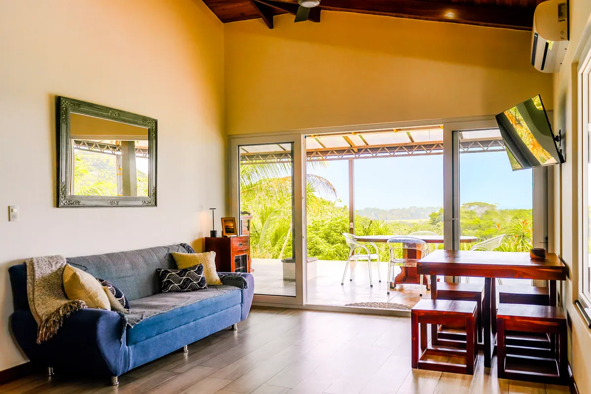 Open living room with sliding doors opening onto the deck and jungle view