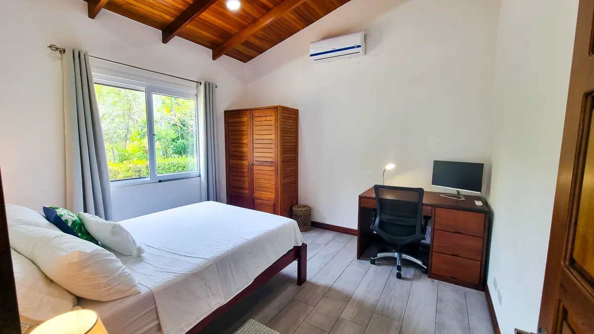 Full view of second bedroom with wardrobe and seating area
